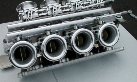 1972 Ford Ranchero - Close-up of a performance throttle body assembly with four individual throttle bores and linkage.