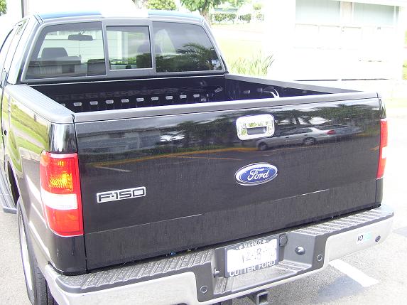 Rear view of a black Ford F-150 pickup truck. Shows the tailgate with Ford logo and F-150 badge