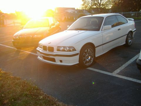 2001 BMW 3 Series - Two BMWs, a coupe and a sedan, are parked in a lot during sunset.