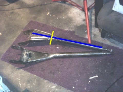 1984 Ford Bronco - Two automotive suspension control arms are shown on a mat, possibly for repair or replacement.
