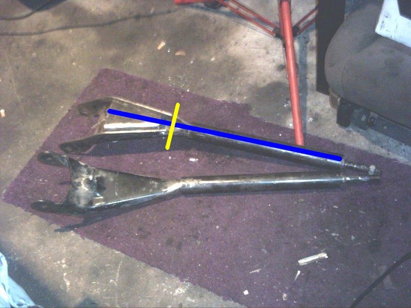 Two metal automotive suspension control arms laid out on a purple mat