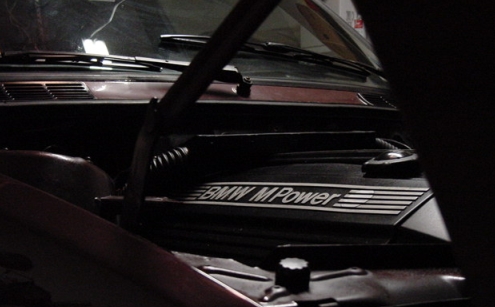Engine bay shot showing BMW M Power cover. Supermotors.net logo visible