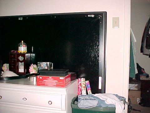 1990 Ford Bronco - Interior scene showing a dresser with various objects on top and a large black panel on the wall.