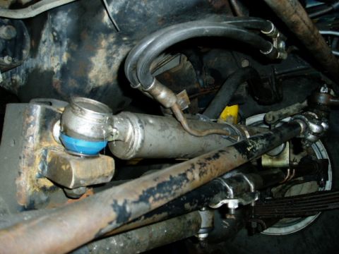 2000 Ford E350 - Underside view of a vehicle's steering system components, including a hydraulic cylinder and linkage.