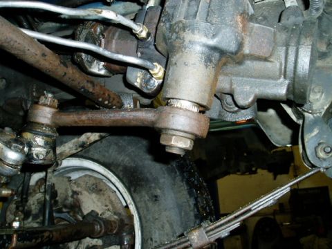 2000 Ford E350 - Close-up view of the steering linkage and power steering gearbox assembly, showing various mechanical components.