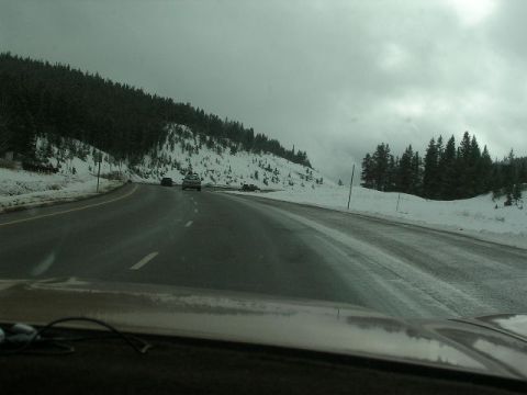1975 Ford Ranchero - Driving on a snowy mountain highway with overcast skies and two vehicles ahead.
