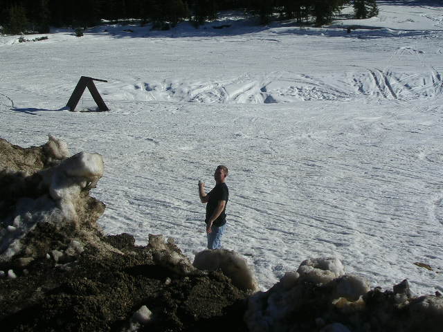 Man standing in a snowy field with trees in the background