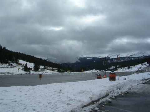 1975 Ford Ranchero - A winter scene unfolds with snow-covered mountains under a cloudy sky, a parking area and a Supermotors.net watermark.