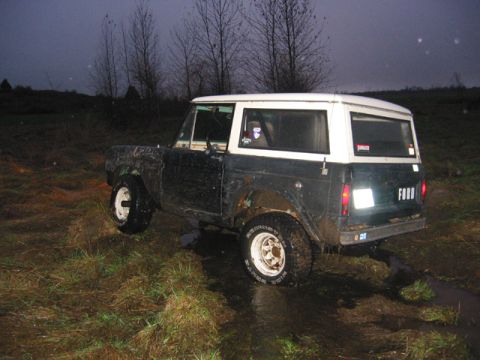 1968 Ford Bronco - 1968 Ford Bronco sits in a muddy, wet field under a dark sky.