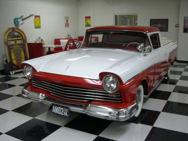 1957 Ford Ranchero, two-tone red and white, parked indoors on a checkered floor