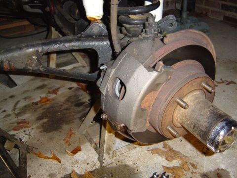 1986 Ford Bronco - Close-up view of a vehicle's brake system, showing the caliper, rotor, and hub assembly.