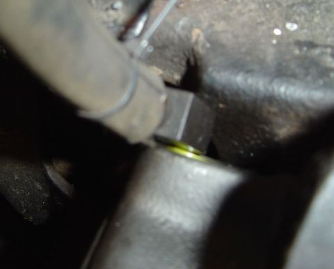 1986 Ford Bronco - A close-up view of a brake line fitting, showing a small amount of yellow fluid.