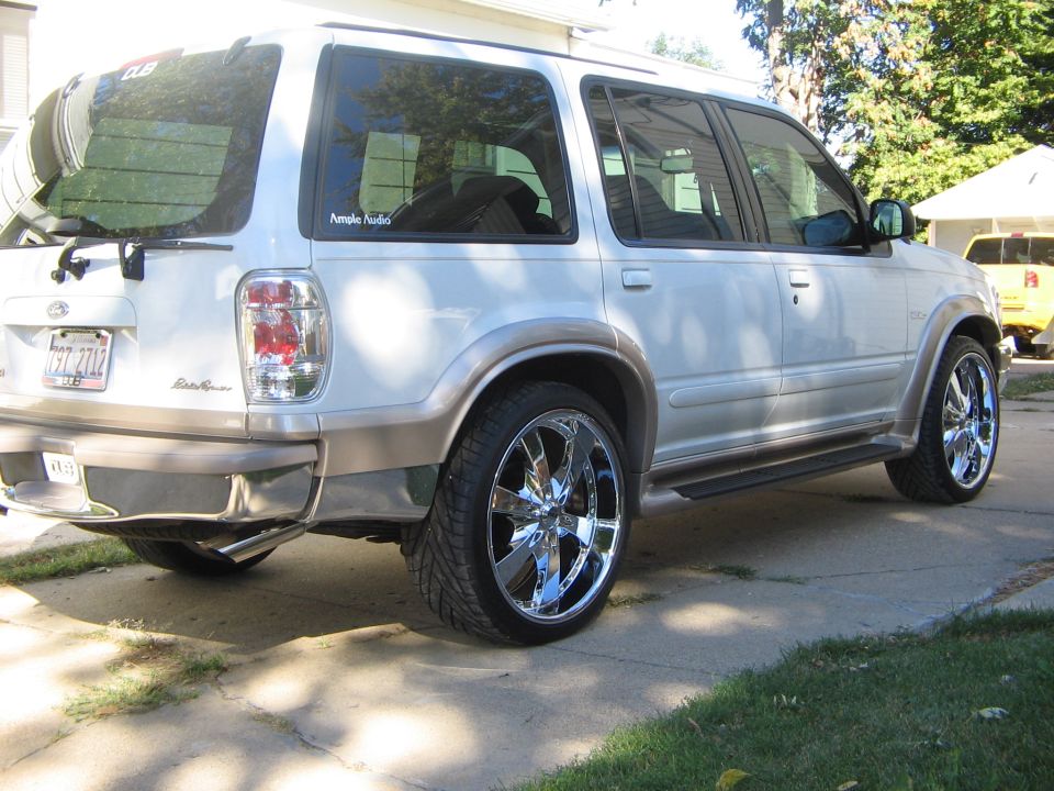White 2001 Ford Explorer SUV with chrome rims and tan trim, viewed from the rear three-quarter angle