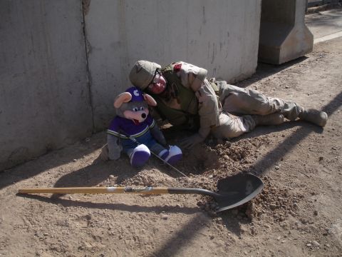 1996 Ford Probe - A soldier and a plush toy are on the ground next to a concrete barrier with a shovel.