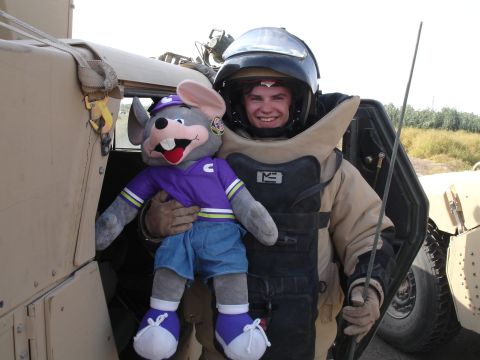 1996 Ford Probe - A smiling soldier in protective gear poses with a stuffed toy next to a military vehicle.