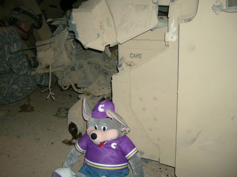 1996 Ford Probe - A soldier and a Chuck E. Cheese mascot are near a military vehicle. The word 'CARC' is visible on the vehicle.