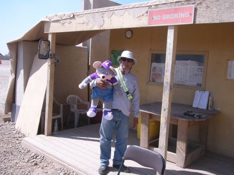 1996 Ford Probe - A man stands outside a building, holding a large plush toy of Chuck E. Cheese.