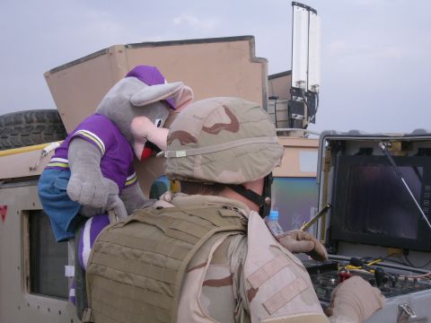1996 Ford Probe - A soldier and a mascot plush toy are positioned near a military vehicle's control panel.