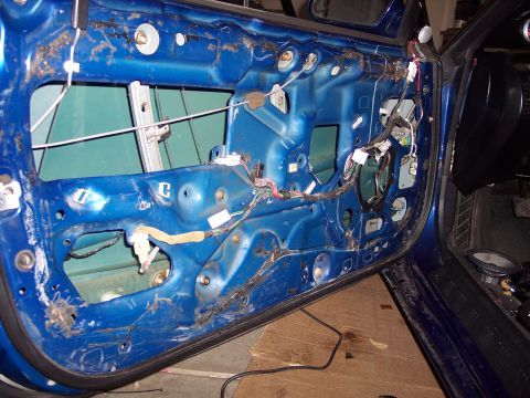 1995 Ford Probe - Interior view of a blue car door with wiring and window components exposed.