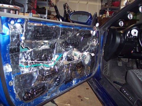 1995 Ford Probe - The interior of a car door is shown with sound deadening material applied to the inner panel.