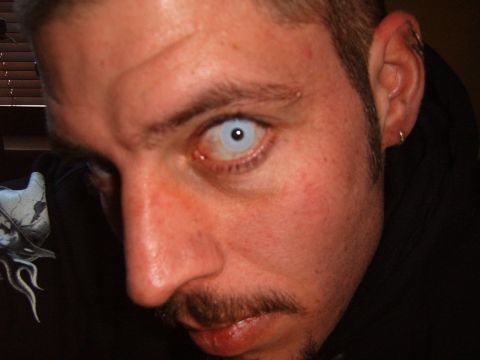 1993 Ford Bronco - Close-up of a man's face, showing his eye with a white contact lens and a mustache.