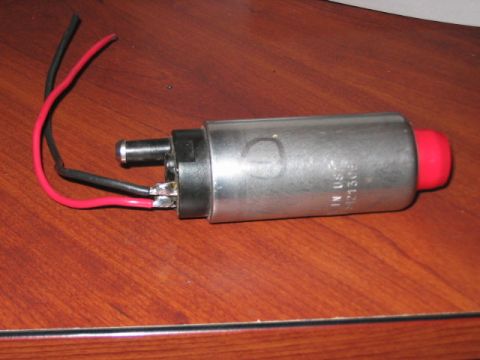 1991 Ford Bronco - A silver fuel pump with a red cap and attached wires rests on a wooden surface.