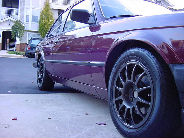 Purple BMW E30 coupe side view with aftermarket wheels