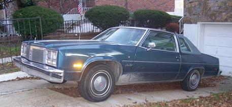 1999 Ford Crown Victoria - This 1977 Oldsmobile Delta 88 sedan is parked in a driveway next to a garage.