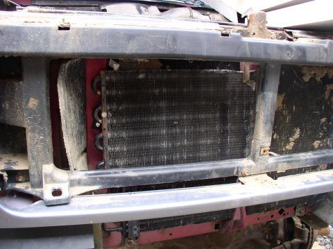 1996 Ford F-250 - The front of a 1996 Ford F-250 shows its radiator and condenser assembly, covered in dirt and grime.