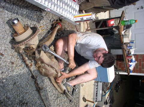 1996 Ford F-250 - A mechanic works on a truck's suspension system, which has been removed from the vehicle.