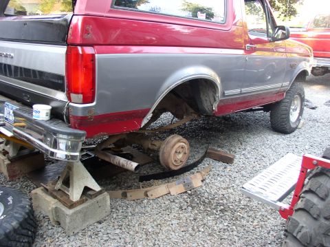 1996 Ford F-250 - Rear suspension work on a 1996 Ford Bronco, with a second Ford truck in the background.