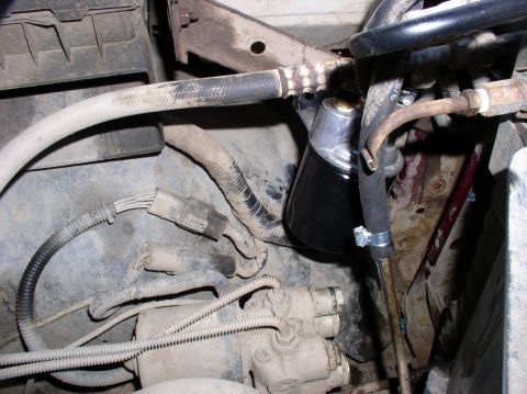 1996 Ford F-250 - Close-up view of engine compartment parts, including hoses, wiring, and a fuel filter.