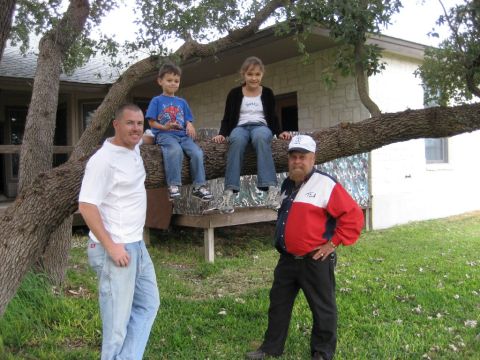 1986 Ford Bronco - Group of people standing and sitting outside near a house and trees.
