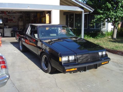 1991 Ford Bronco - A black coupe is parked in a driveway, with a portion of another vehicle visible to the left.