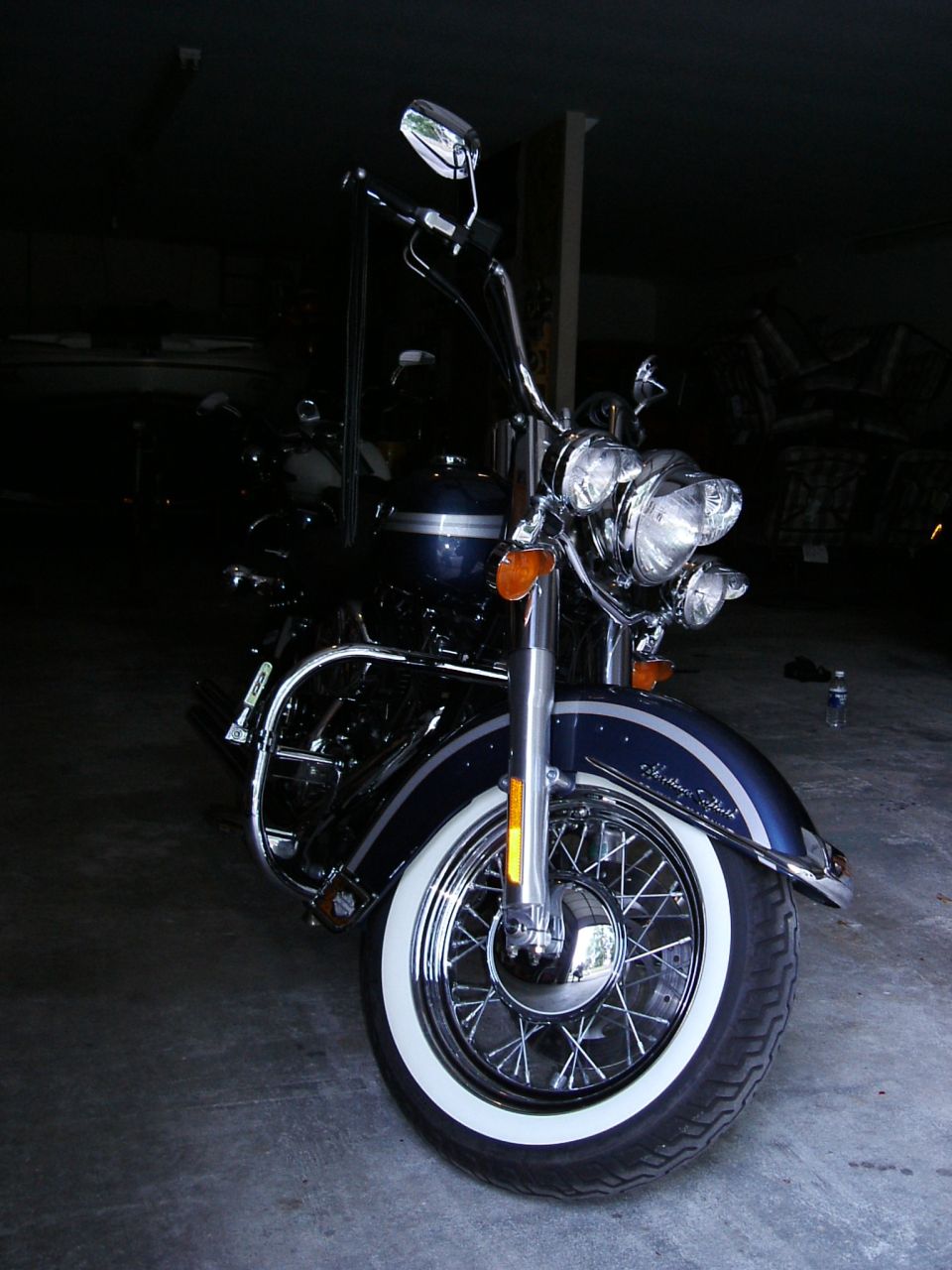 Dark blue Harley-Davidson Softail motorcycle with chrome accents and whitewall tires, seen from the front