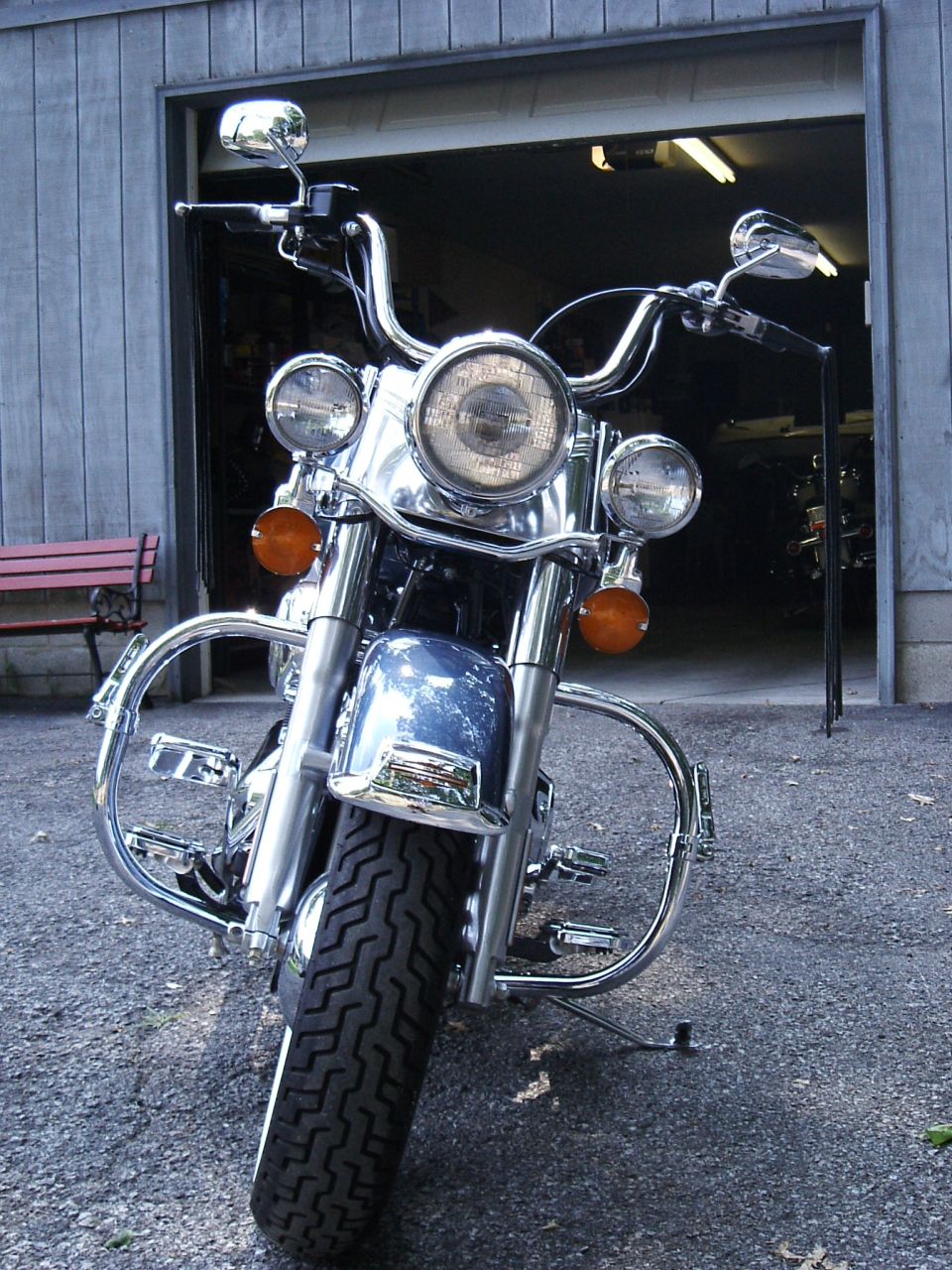 Blue 2003 Harley-Davidson Softail motorcycle parked in front of a garage, chrome accents, front view