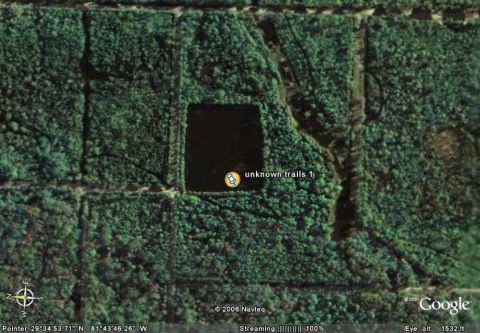 1989 Ford Bronco - This satellite image shows a wooded area with a dark pond and trails, labeled as 'unknown trails 1'.