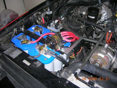 1996 Ford Bronco - The engine compartment shows a modified dual battery system with prominent red cabling and a large alternator.