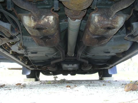1996 Ford Crown Victoria - The underside of a car is visible, with a focus on the exhaust system and drivetrain components.