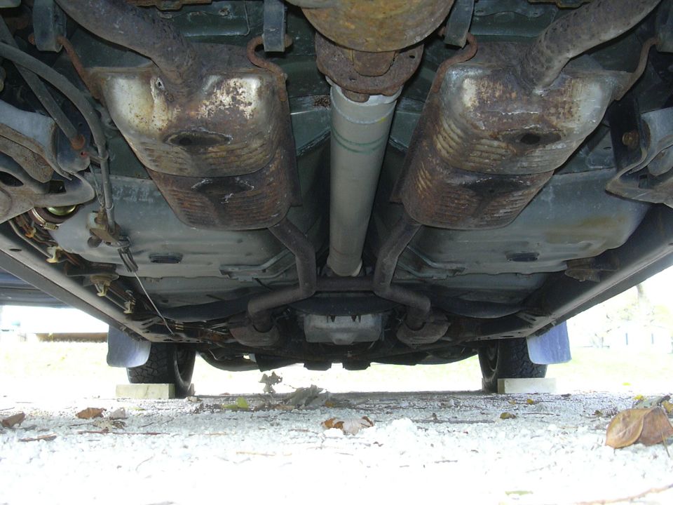 Undercarriage view of dual catalytic converters, driveshaft and exhaust pipes
