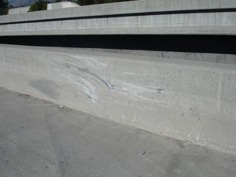 1993 Ford Taurus - Concrete barrier on an overpass shows evidence of a collision with scrape marks.
