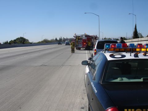 1993 Ford Taurus - Emergency responders are on the scene of an incident on a multi-lane highway.