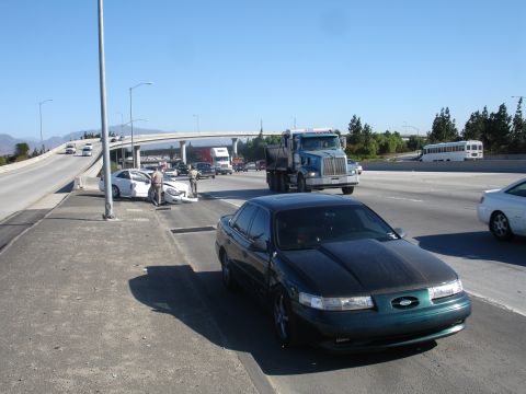 1993 Ford Taurus - Highway scene with a crashed white car and a dark green 1993 Ford Taurus on the shoulder.