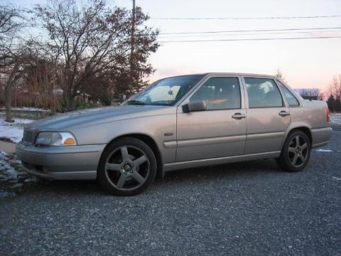1993 Ford Probe - A silver sedan is parked on a gravel surface with trees and a dusky sky in the background.