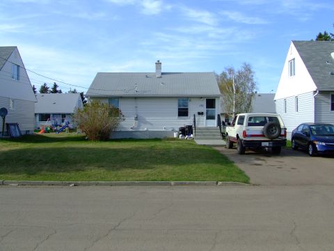 1990 Ford Bronco - A white Ford Bronco is parked in the driveway of a suburban house, with a blue sedan also visible.