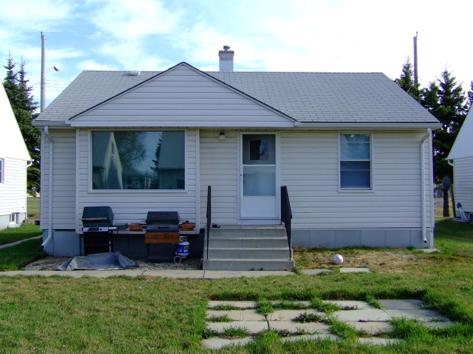 White house with two grills on the side yard