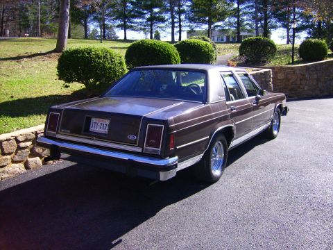 1982 Ford Crown Victoria LTD - This brown sedan features a classic design with chrome accents and a visible license plate.