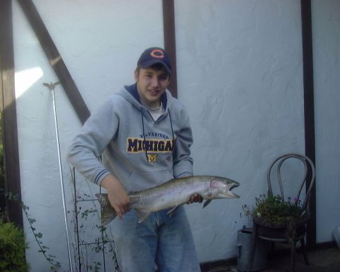 1985 Ford F-150 - A man proudly displays a large fish he has caught.