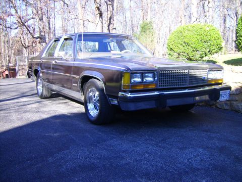 1982 Ford Crown Victoria LTD - This sedan features a prominent grille and chrome wheels, viewed from the front three-quarter angle.