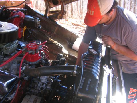 1979 Ford Bronco - A person works on the engine of a vehicle, focusing on the MSD distributor and radiator components.